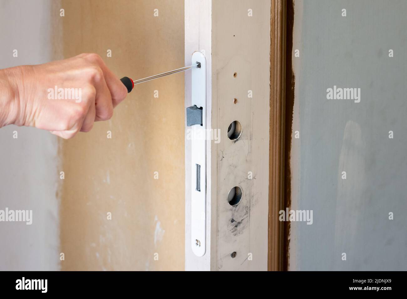 Interior renovation. Replacement of a door lock and handle Stock Photo