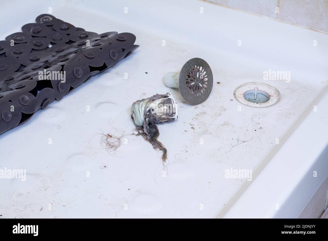 Clogged shower. Dirty shower tray, with hair tangled in the drain and grid Stock Photo Alamy