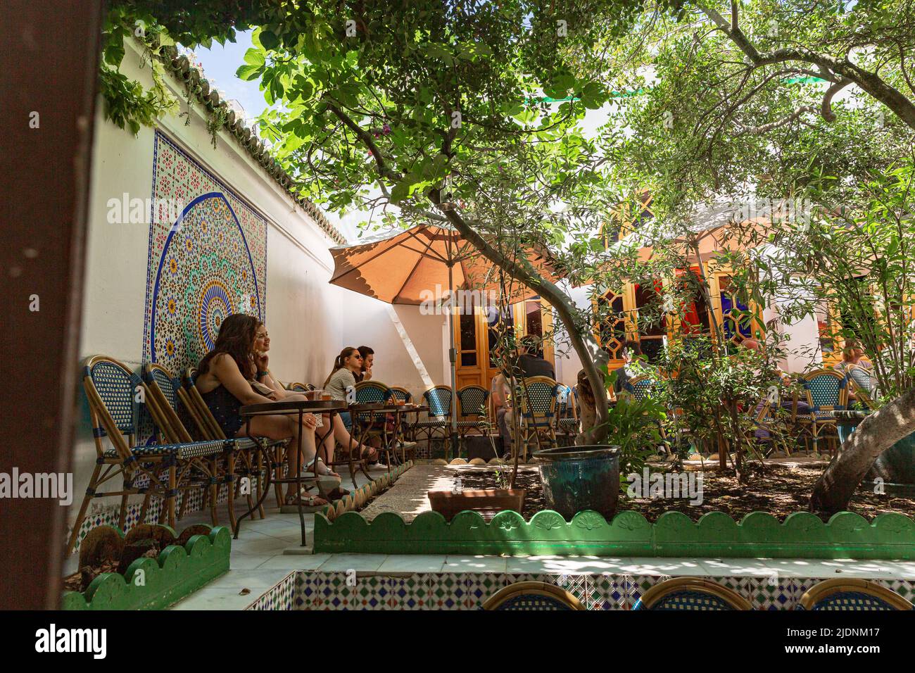 Great Mosque of Paris cafe patrons sit at small tables in the shade of fig trees Stock Photo