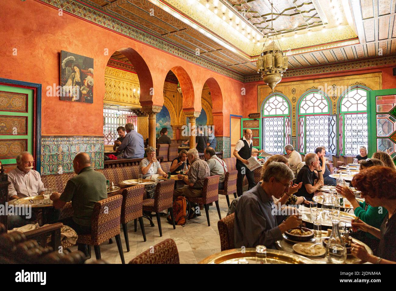 Great Mosque of Paris cafe patrons sit at small tables in the shade of fig trees Stock Photo