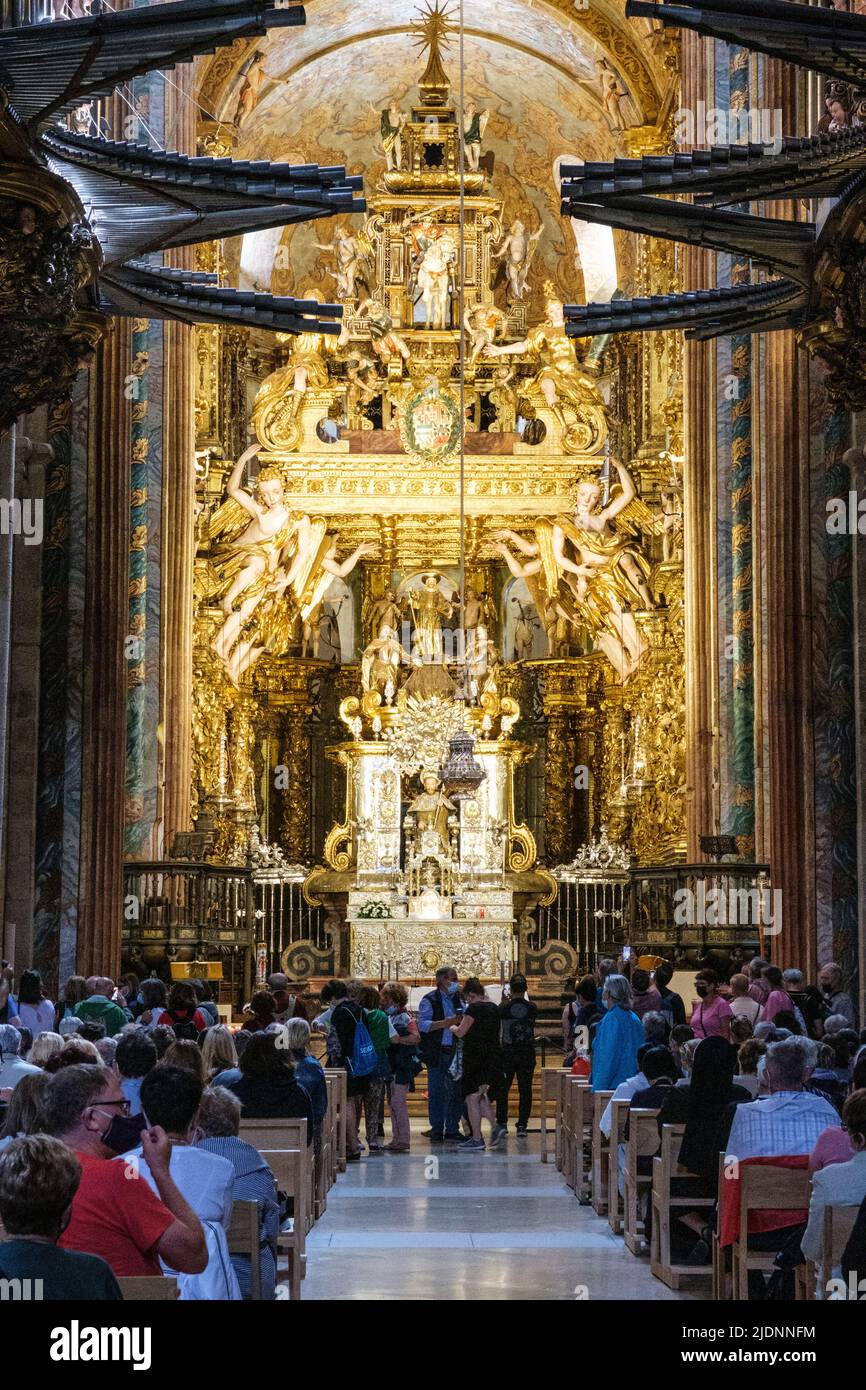 Spain, Santiago de Compostela, Galicia. People athering for Mass, Cathedral of Santiago de Compostela. Main Altar in background. Stock Photo