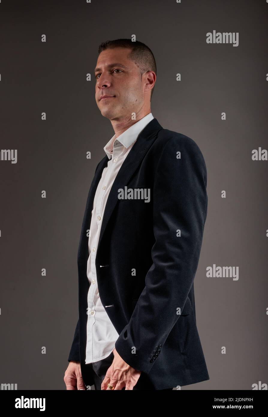 A young, elegant man dressed in a white shirt and black jacket Stock