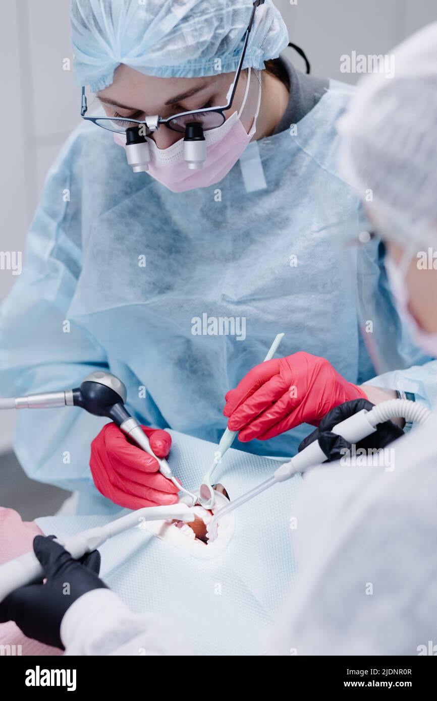 A female dentist with dental instruments cleans her teeth at a dental clinic. High quality photo Stock Photo