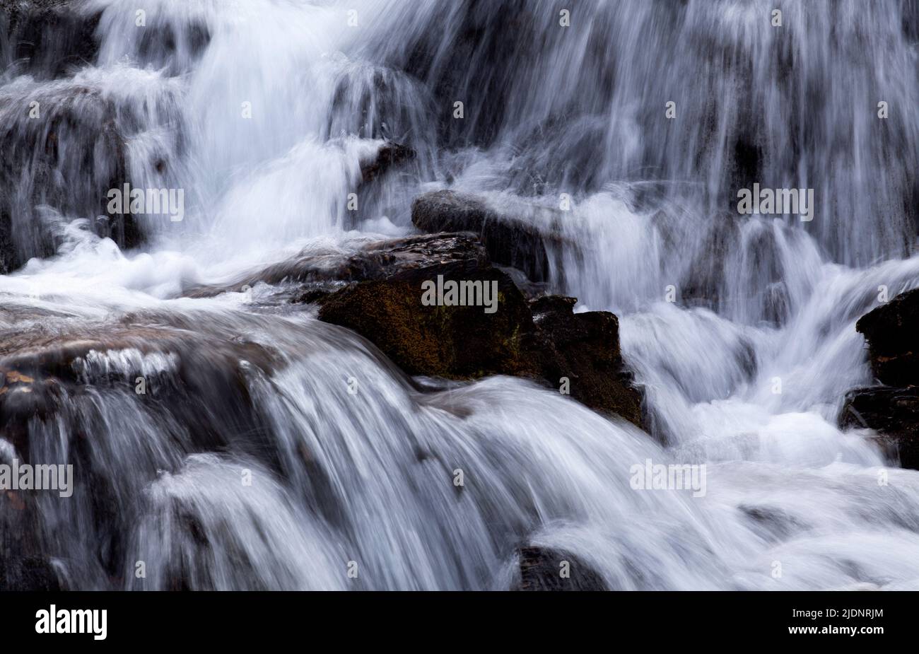 A small creek, brook, jokk flows through the valley at a slope in the ...