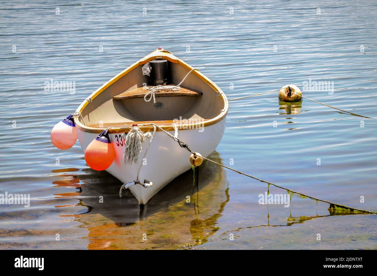 This small whaling boat dingy tied up just off shore is one of the best dinghies anyone could own, and it looks like its owner cares for it very much Stock Photo