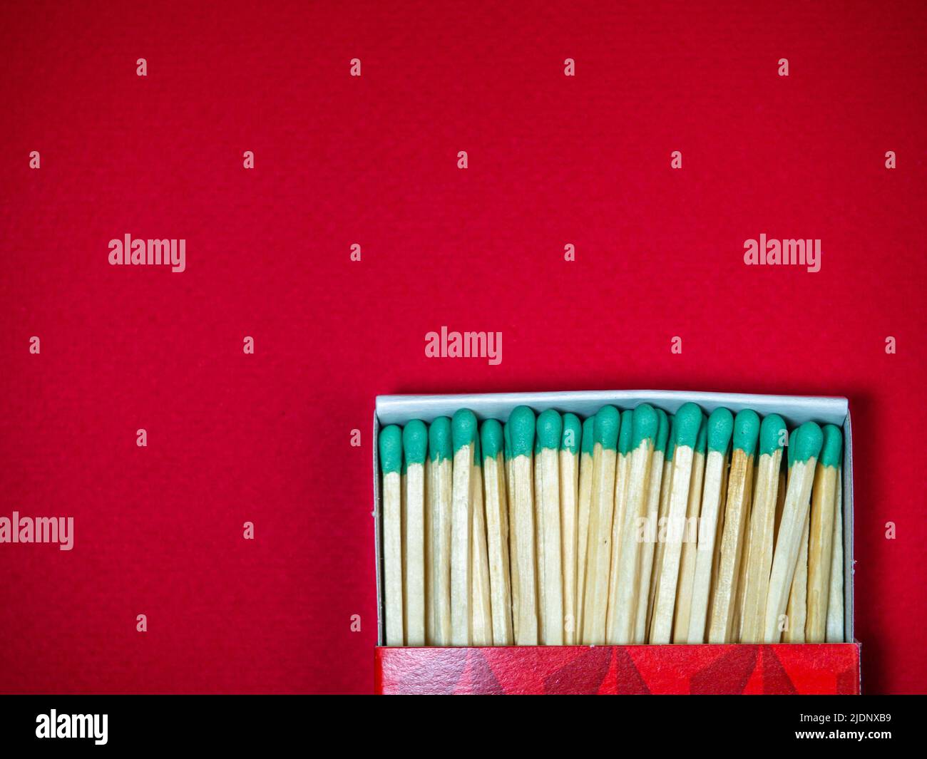 Large matches with green heads on a red background. Open matchbox Stock ...