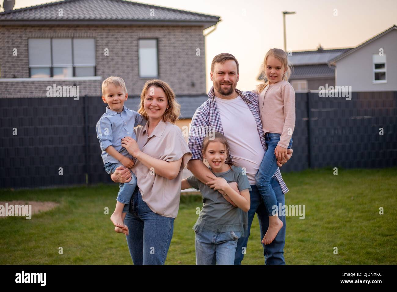 family portrait. happy family mom, dad, daughter, son are relaxing and having fun in the backyard of their house. Stock Photo