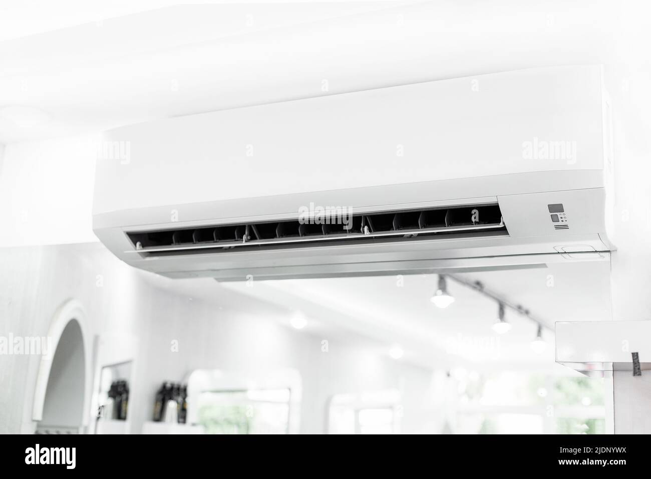 White air conditioner hanging on white wall. Air cool. Stock Photo