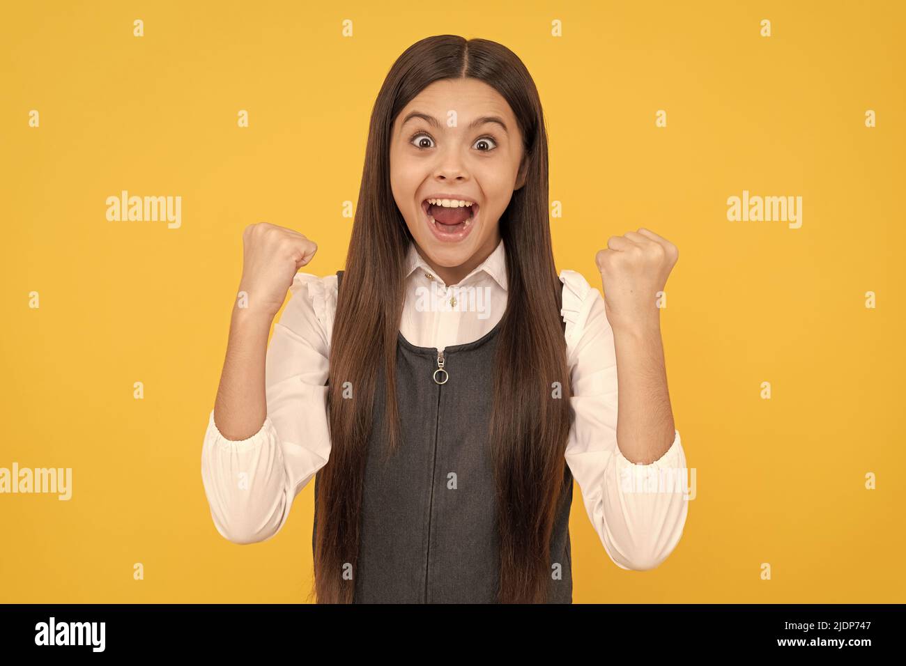 Scholarship winner. Happy teenage winner yellow background. Girl child give winning gesture Stock Photo