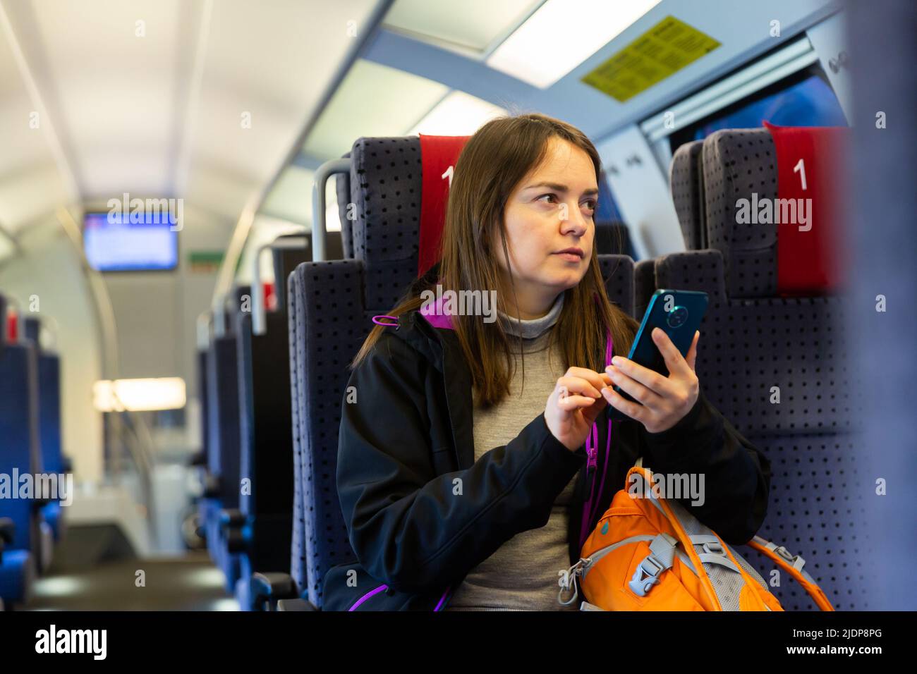 Female traveler using mobile phone while riding train Stock Photo - Alamy