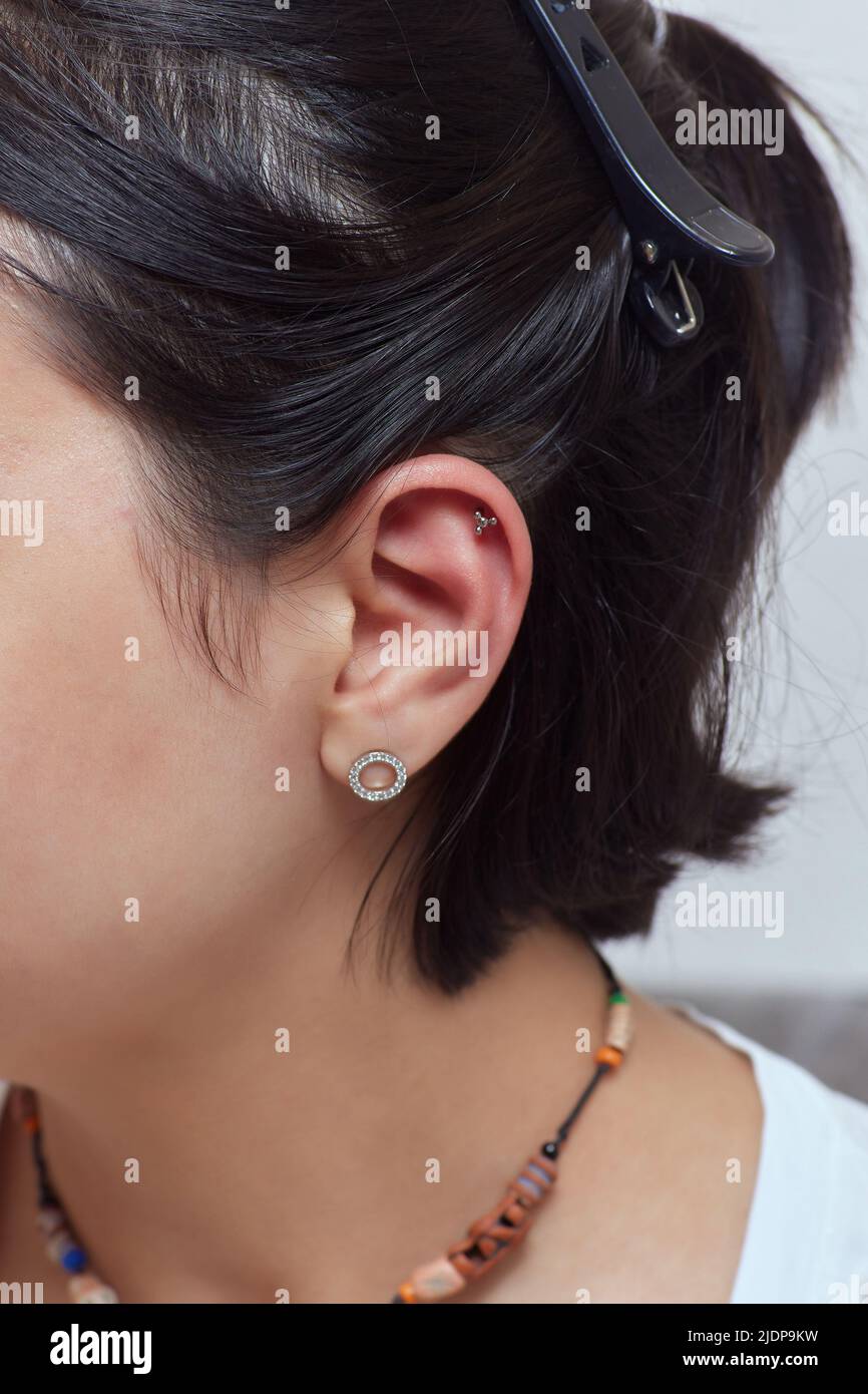 piercings on an ear. Conch and helix piercings close up. Professional