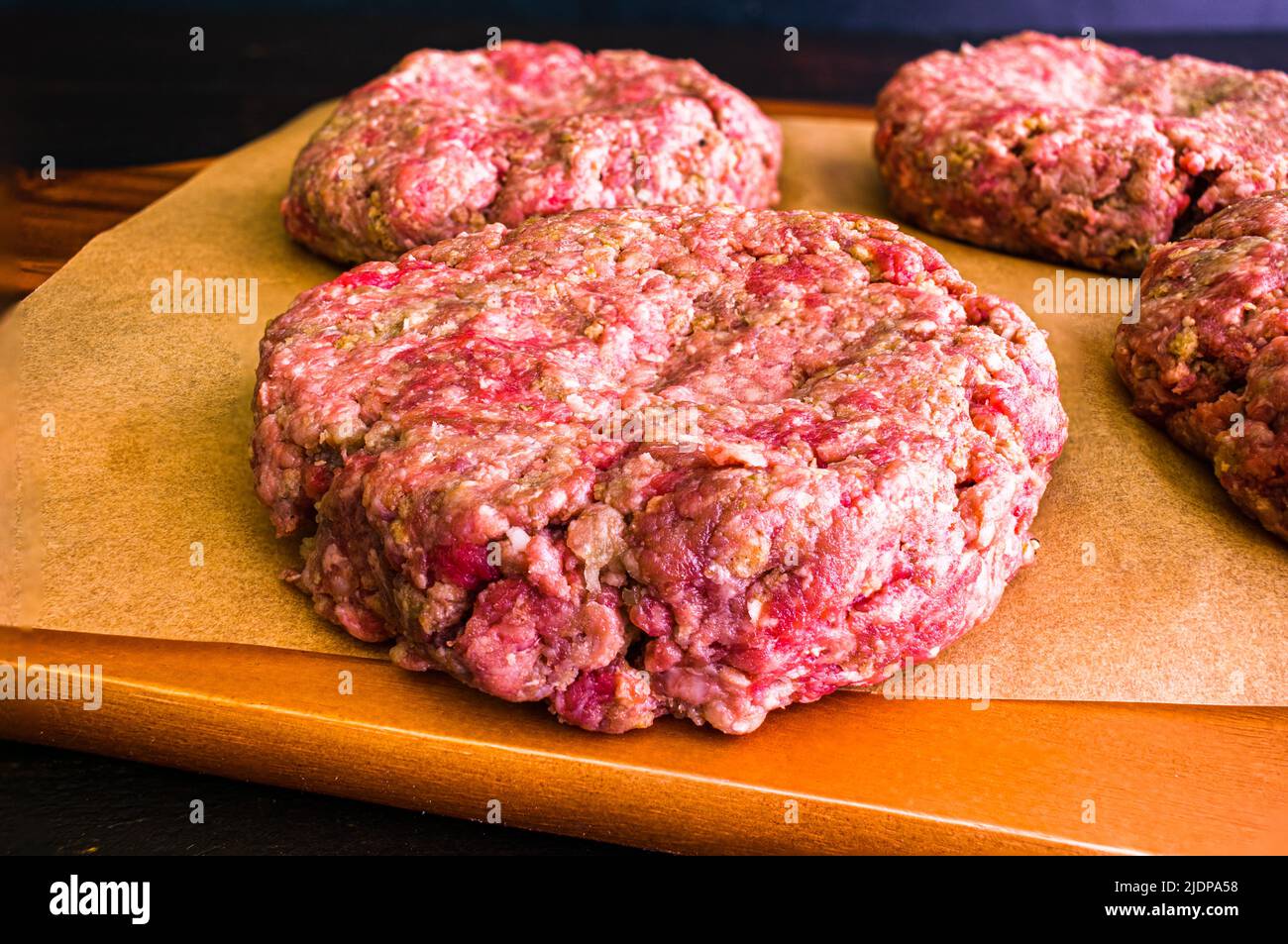 Raw Hamburger Patty Seasoned with Pesto and Garlic Closeup view of