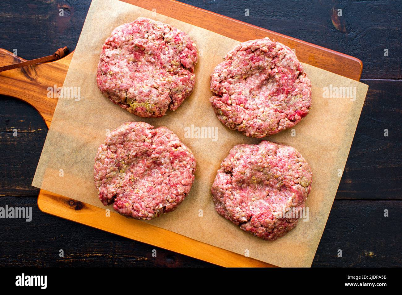 Raw Hamburger Patties Seasoned with Pesto and Garlic Overhead view of