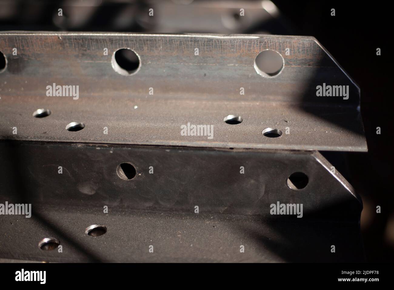 Holes in steel from drilling. Metal blank. Steel profile is drilled