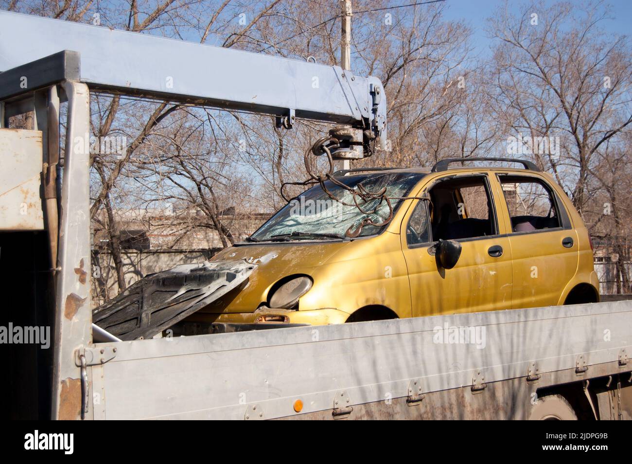 Tow truck with a broken car after an accident in its back. Stock Photo
