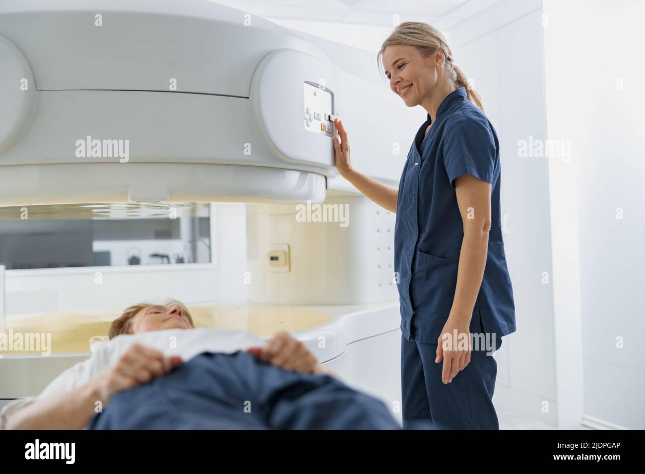 Radiologist controls MRI or CT or PET Scan with female patient