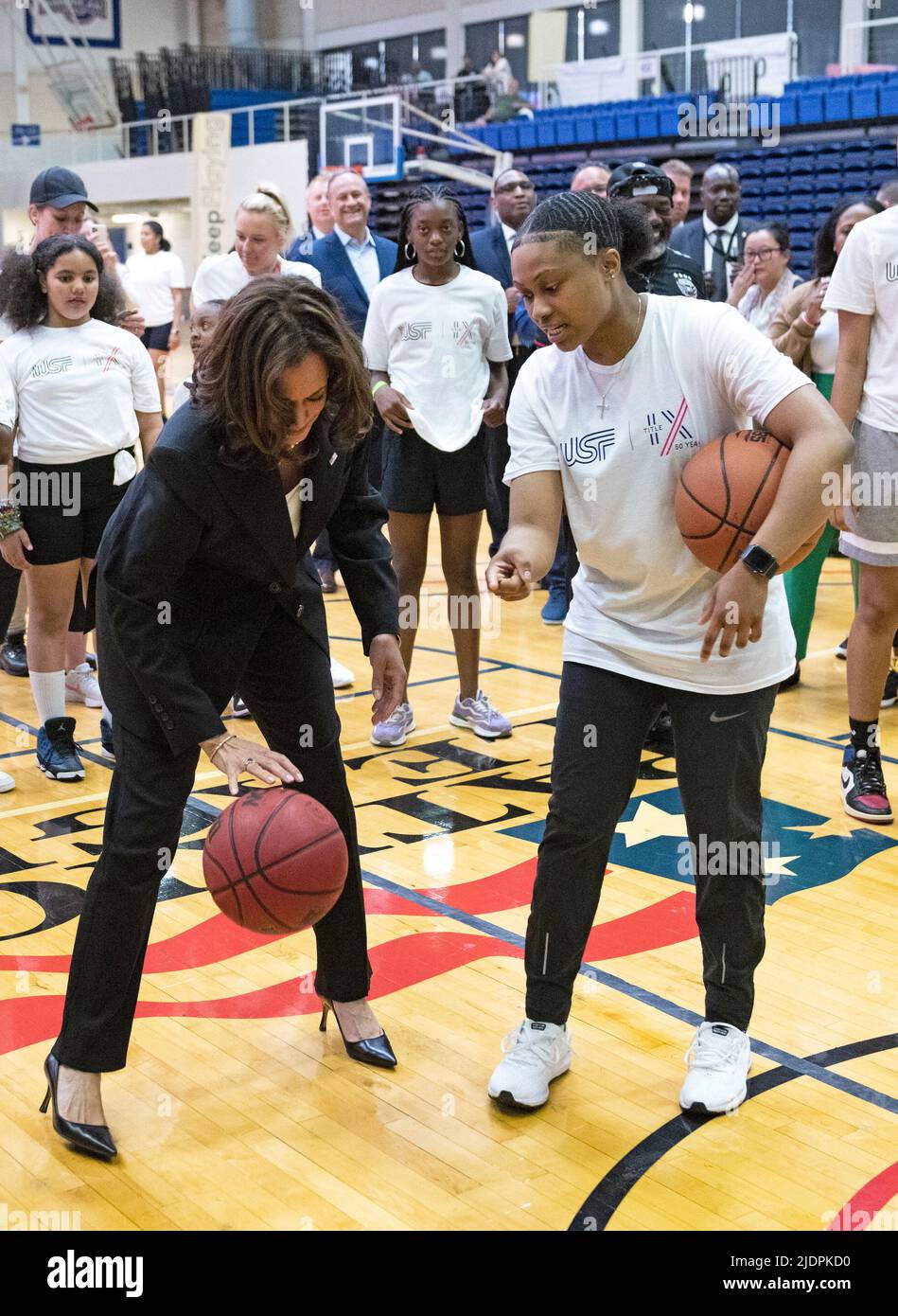 United States Vice President Kamala Harris dribbles a basketball as she  attempts to make a basket during a surprise visit to a Field Day hosted by  the Department of Education and the