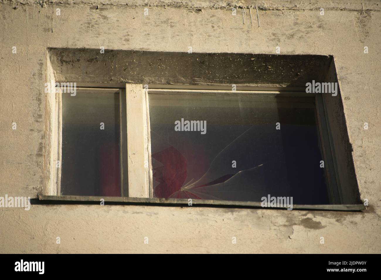 Broken window in building. Glass cracked. Crack in window. Old house is