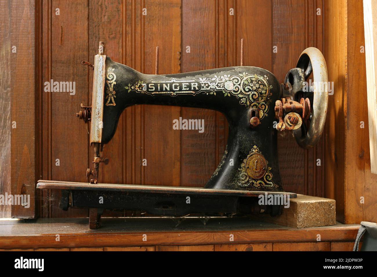 Germany, Lower Saxony, Hambuehren, 23 of April 2022. Antique hand sewing machine SINGER. Very old, dusty, broken covered with cobweb sewing machine Stock Photo