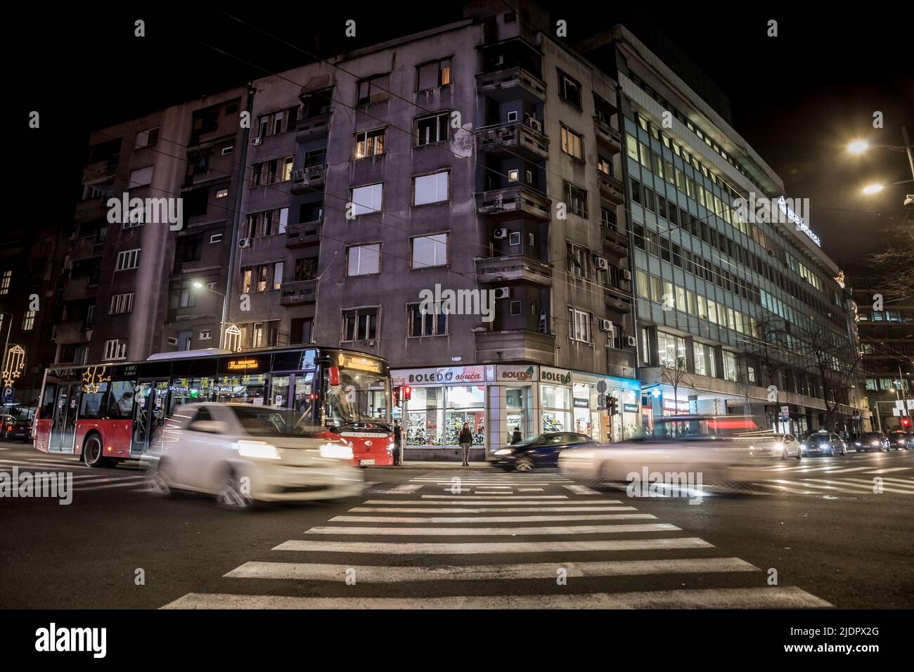 Picture of a zebra crossing in the city center of Belgrade, Serbia, at night, with cars ready to cross the area. It's located in Stari Grad, the busie Stock Photo