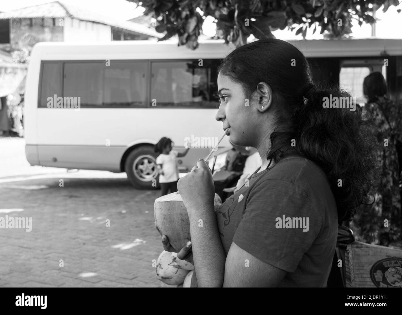 A little girl drinking king coconut in Galle Fort, Sri Lanka Stock Photo