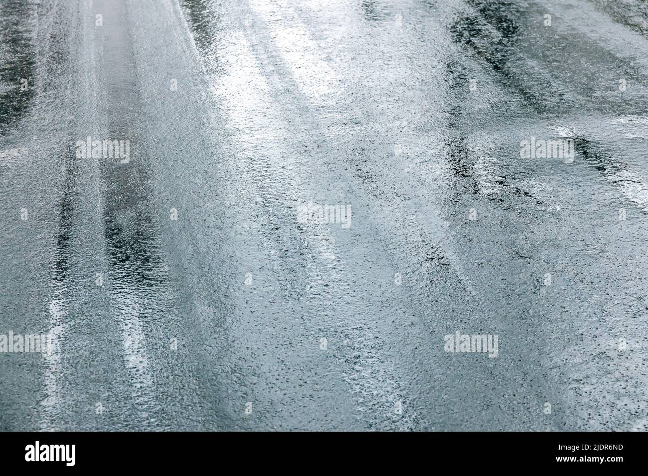 wet asphalt road surface with sky reflecting Stock Photo
