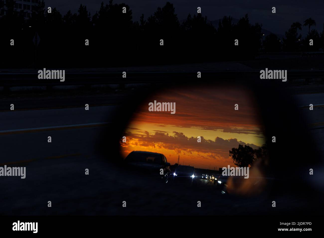 Cars and the sunset are reflected on a car's side rearview mirror while traveling along the 405 freeway in Irvine, California, U.S., June 22, 2022.  REUTERS/Mike Blake Stock Photo
