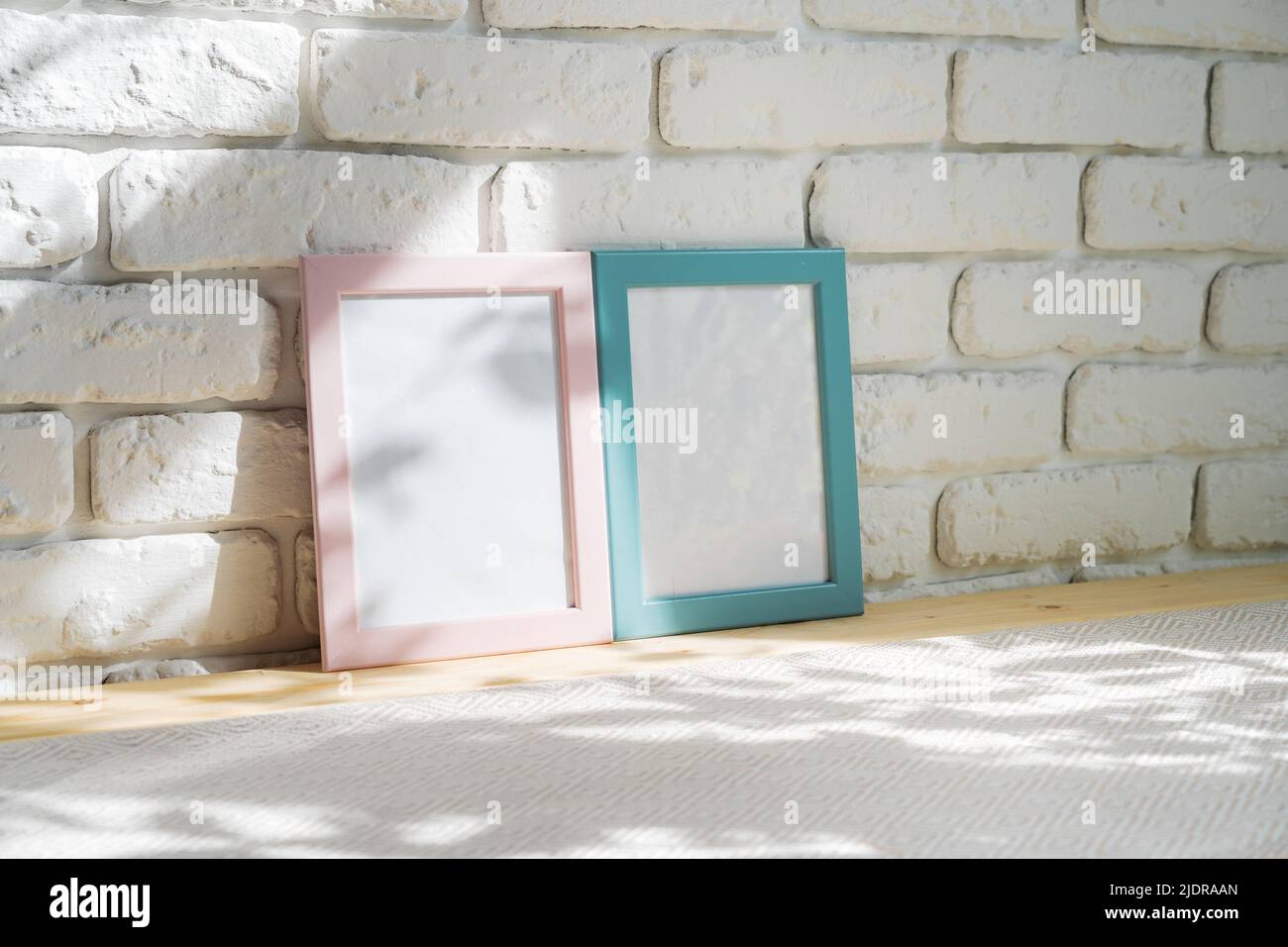 Photo frames on floor over white brick wall Stock Photo