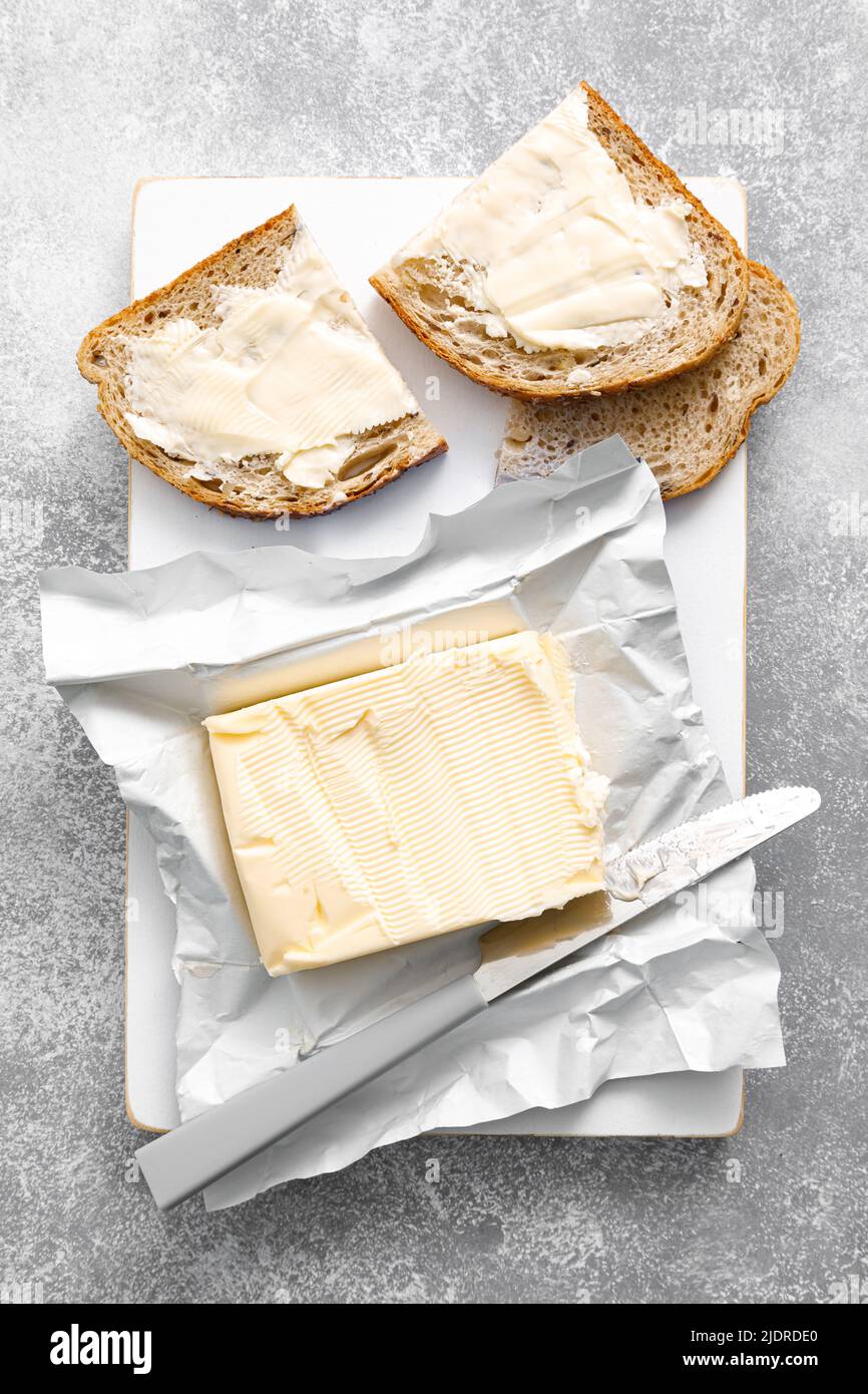 Block of butter with butter knife in a open pack.  Buttering bread Stock Photo