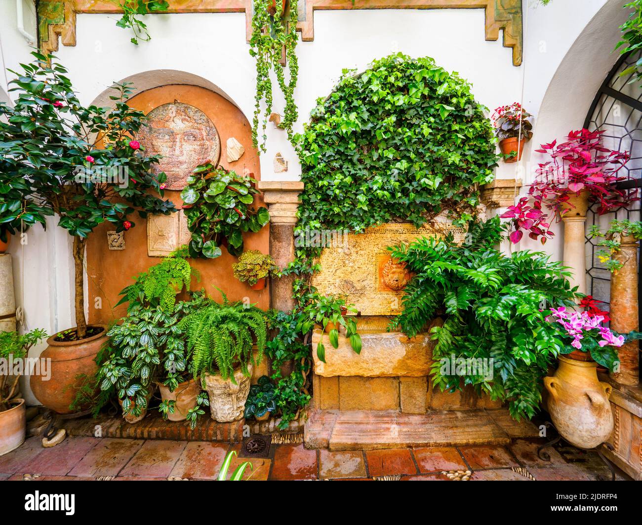 Traditional Andalusian courtyard full of plants and flowers in the old ...
