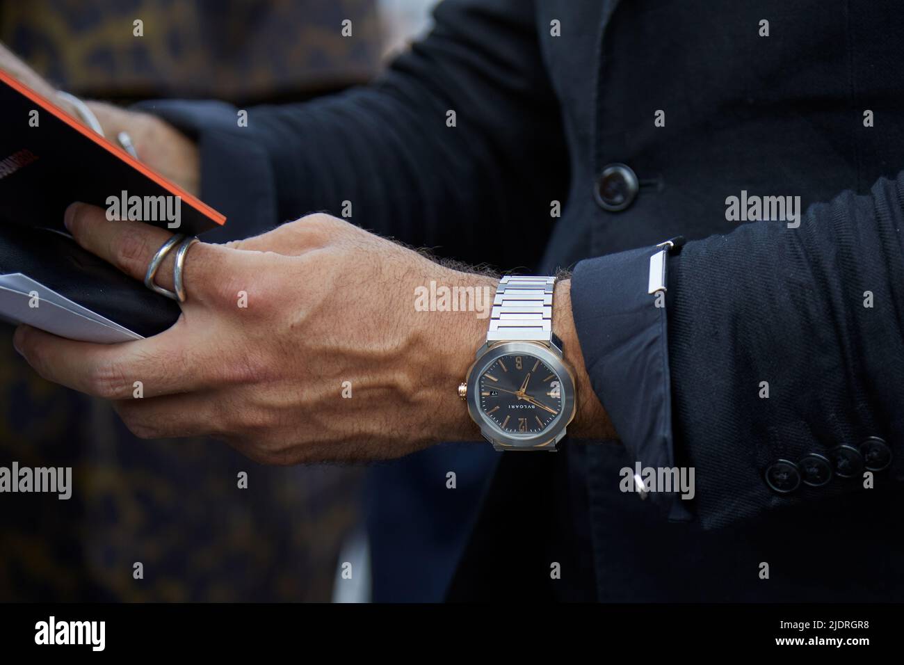 MILAN, ITALY - JUNE 17, 2022: Man with Bulgari watch and black jacket before Dsquared2 fashion show, Milan Fashion Week street style Stock Photo