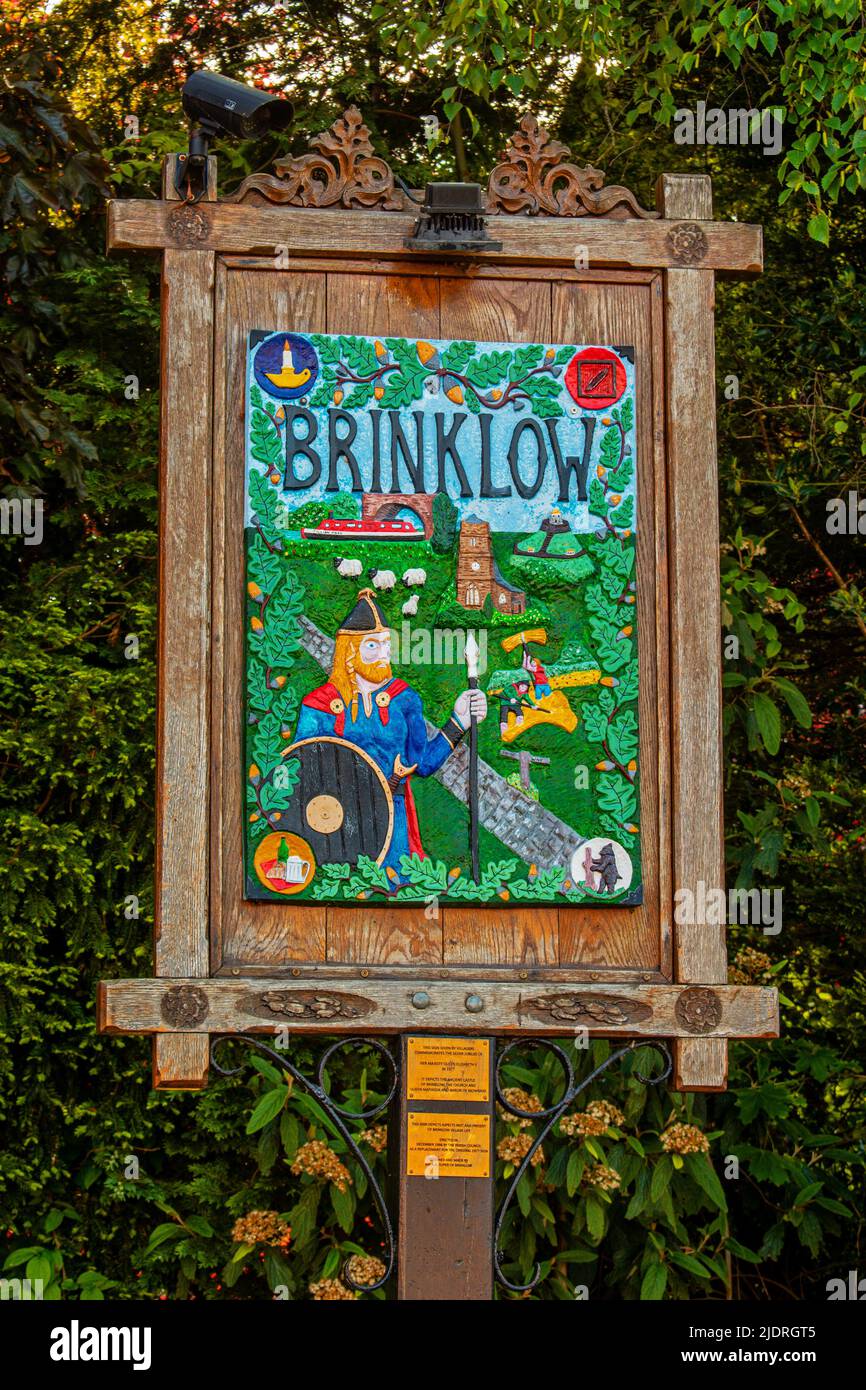 Brinklow village, Warwickshire. Hand painted sign erected in 1998 depicting the castle of Brinklow, the church, Queen Mathilda and the Baron Mobray. Stock Photo