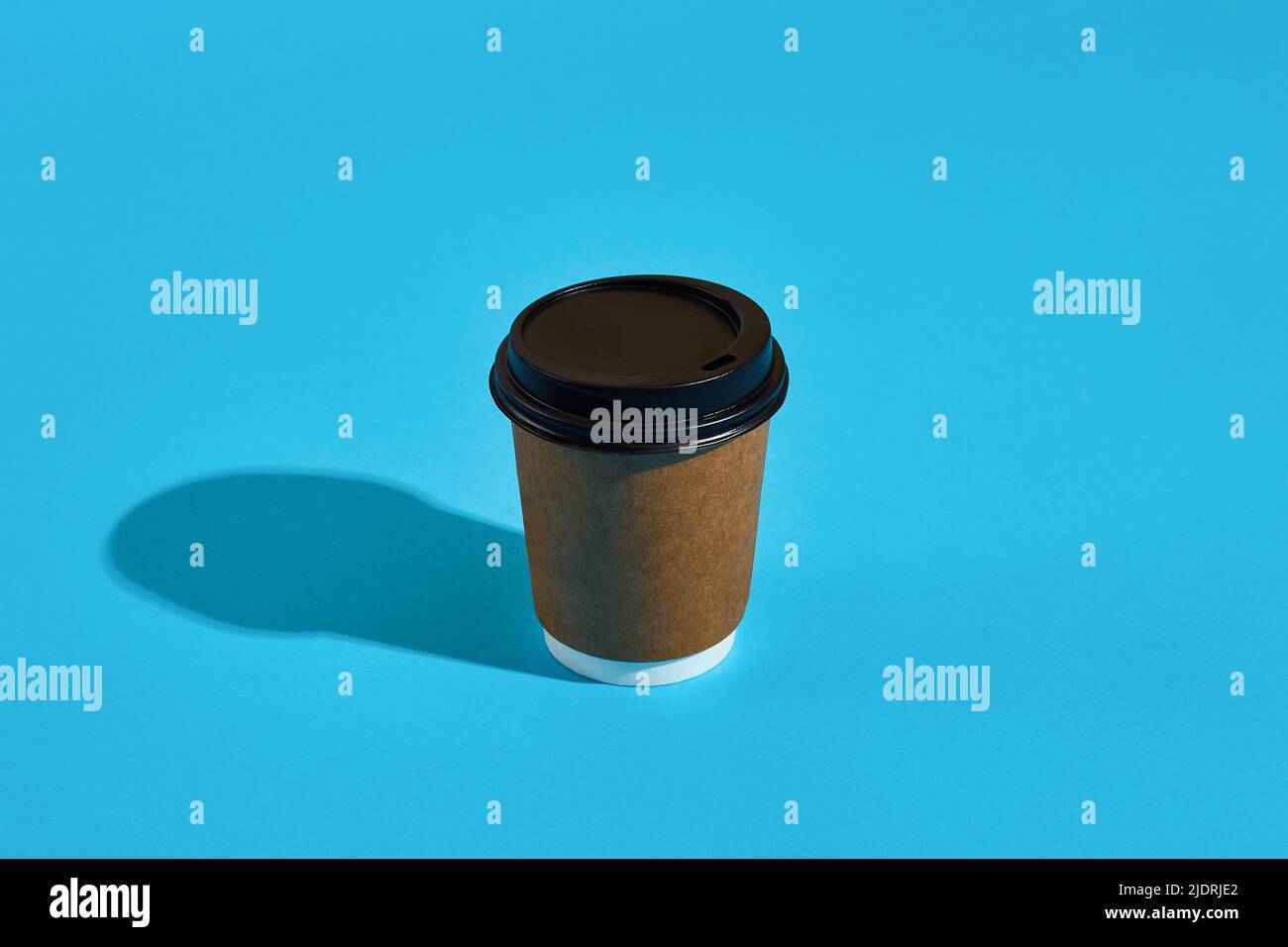 Hot coffee in brown paper cup with black lid on blue background Stock ...