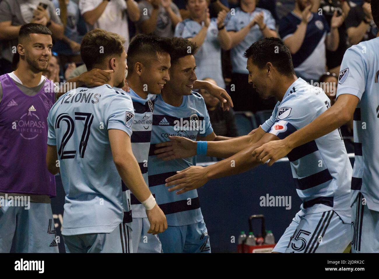Kansas City, Kansas, USA. 22nd June, 2022. Sporting KC midfielder Roger Espinoza #15 (r) reaches out to congratulate Sporting KC midfielder Felipe Hernandez #21 (c-l) for Hernandez' second of double goal of the night. From l-r, adjacent to Hernandez, is Sporting KC midfielders Marinos Tzionis #27 and Cameron Duke #28. Both goals were scored by Hernandez during the second half of the game (Credit Image: © Serena S.Y. Hsu/ZUMA Press Wire) Stock Photo