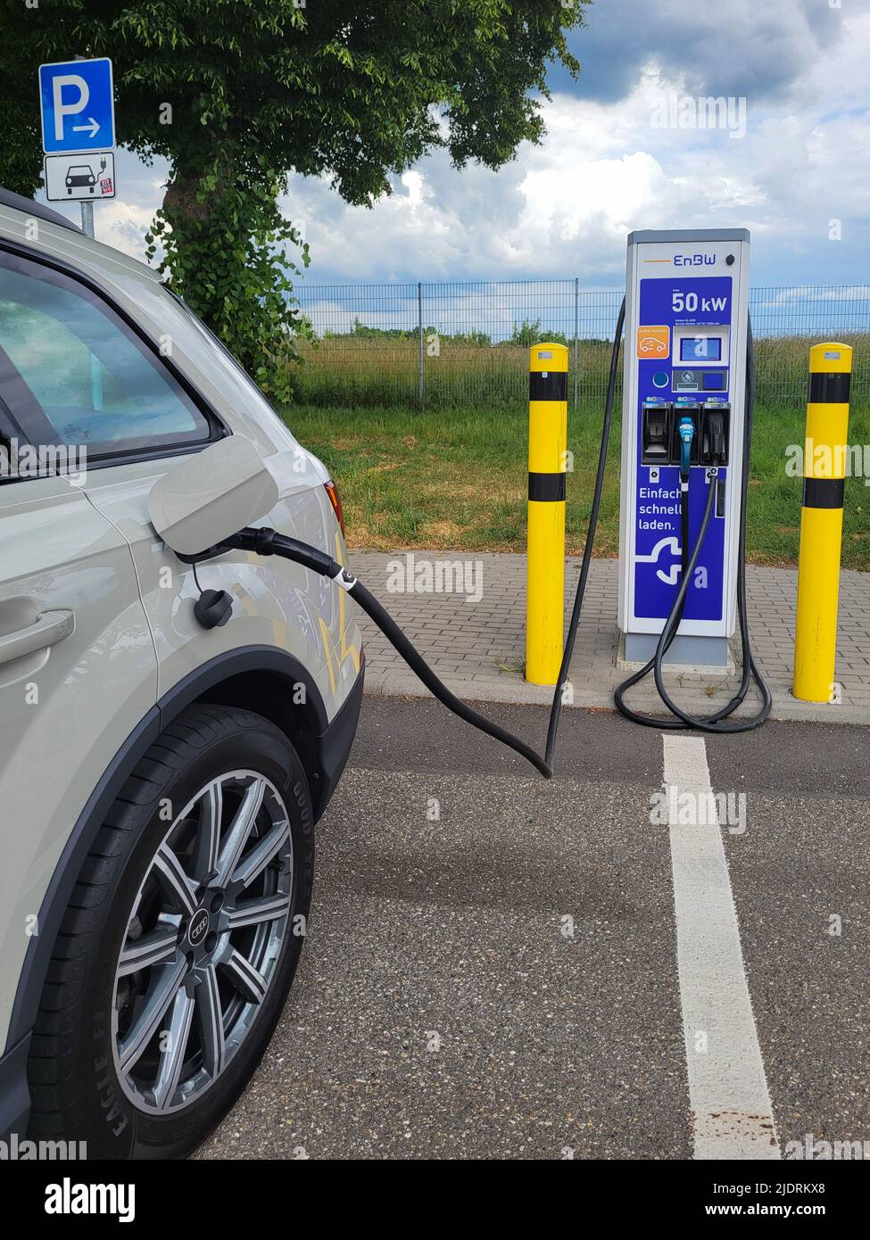 WIDDERN, GERMANY - JUNE 3, 2022: Car connected to a EnBW electric car charger on a Autobahn rest station. Stock Photo