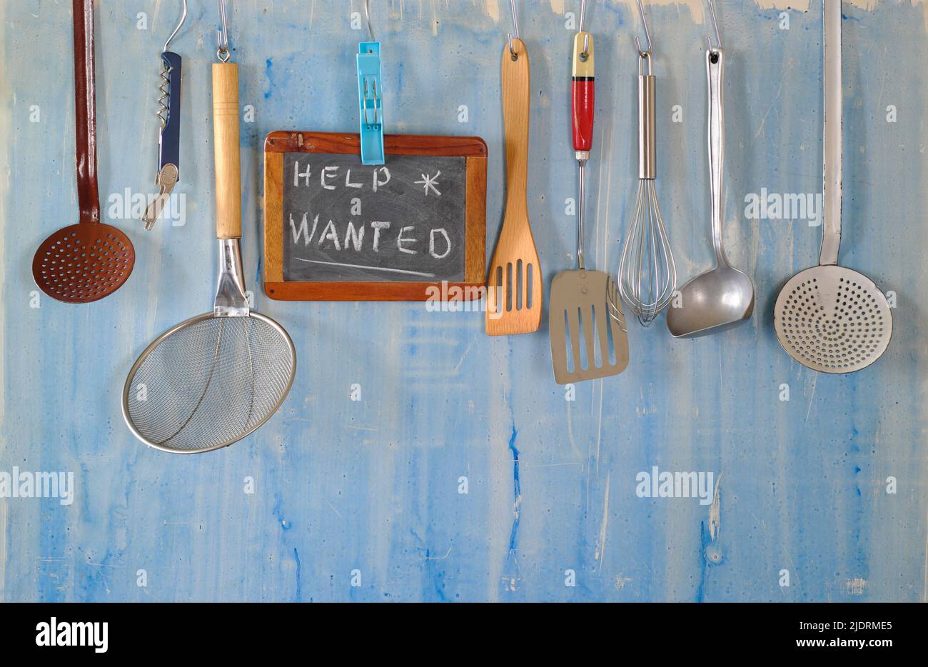 Help wanted sign,restaurant or cafe loking for staff after corona lockdown, kitchen utesnils and message on blackboard Stock Photo