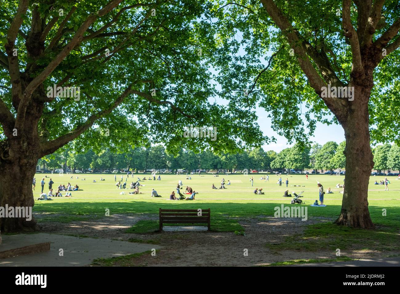 London- May 2022: People relaxing in the sun on Richmond Green in southwest London Stock Photo