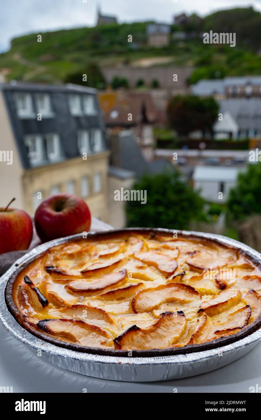 Tasty sweet French dessert, baked apple cake and view on old houses of