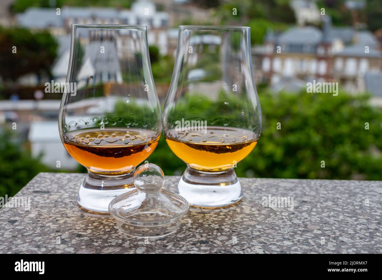 Two drams of scotch whiskey with view on old houses on background