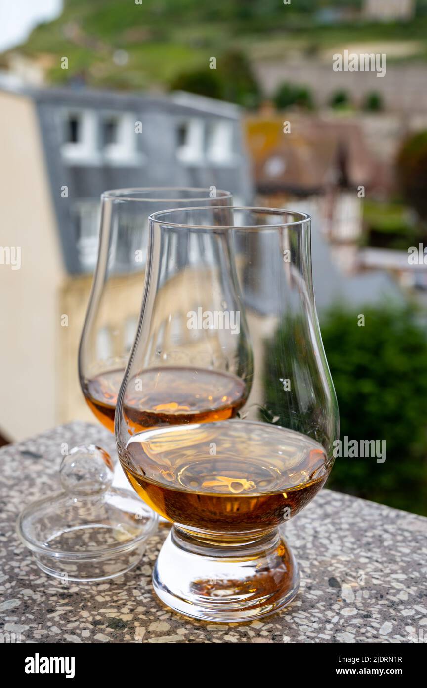 Two drams of scotch whiskey with view on old houses on background