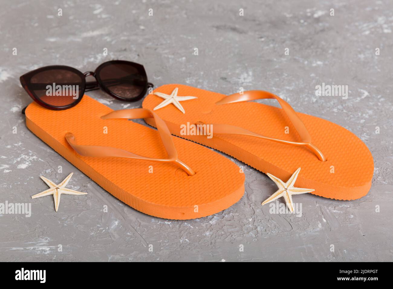 Beach accessories. Flip flops and starfish on colored background. Top ...