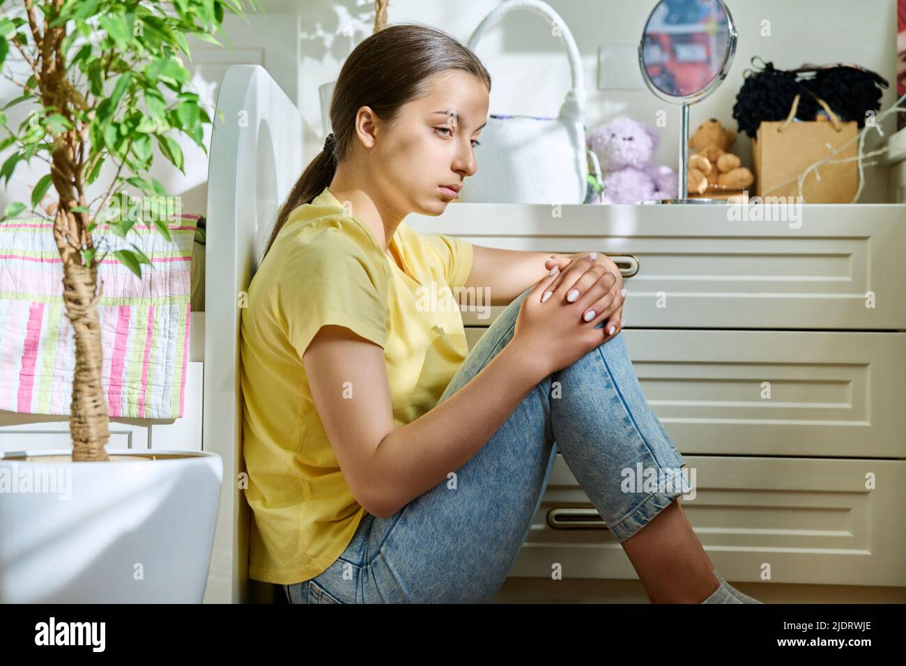 Sad teenage girl sitting on the floor at home Stock Photo - Alamy