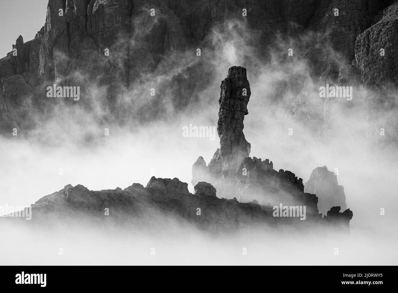 Sunlight at sunrise. Rocky pinnacle and clouds. Monte Paterno mountain in the Sexten Dolomites. Italian Alps. Europe. Black white landscape. Stock Photo