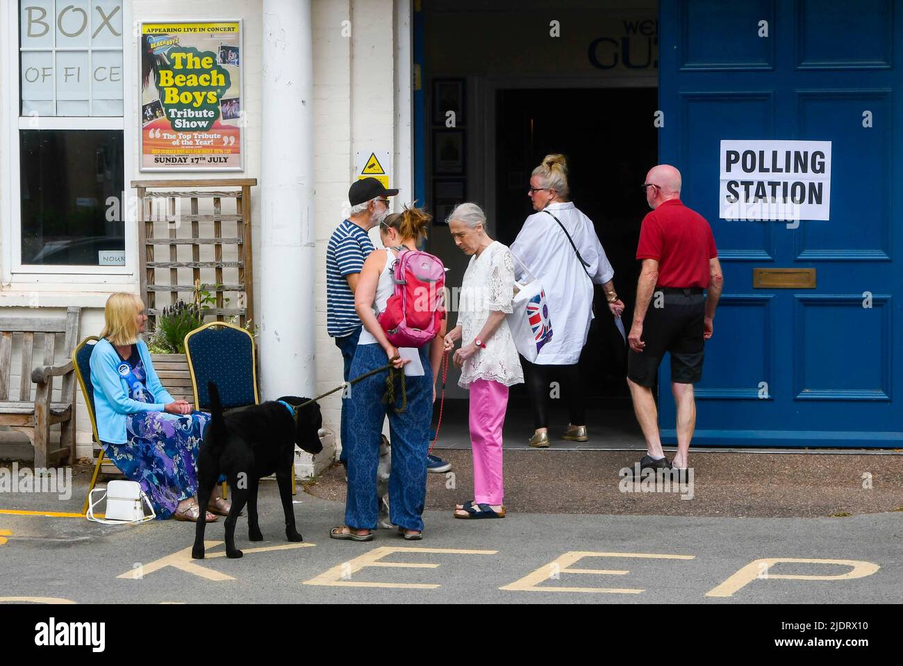 Axminster, Devon, UK.  23rd June 2022.  Voters with dogs enter a polling station at the Guild Hall at Axminster in Devon to cast their vote for the parliamentary election for the Tiverton and Honiton constituency.  Picture Credit: Graham Hunt/Alamy Live News Stock Photo