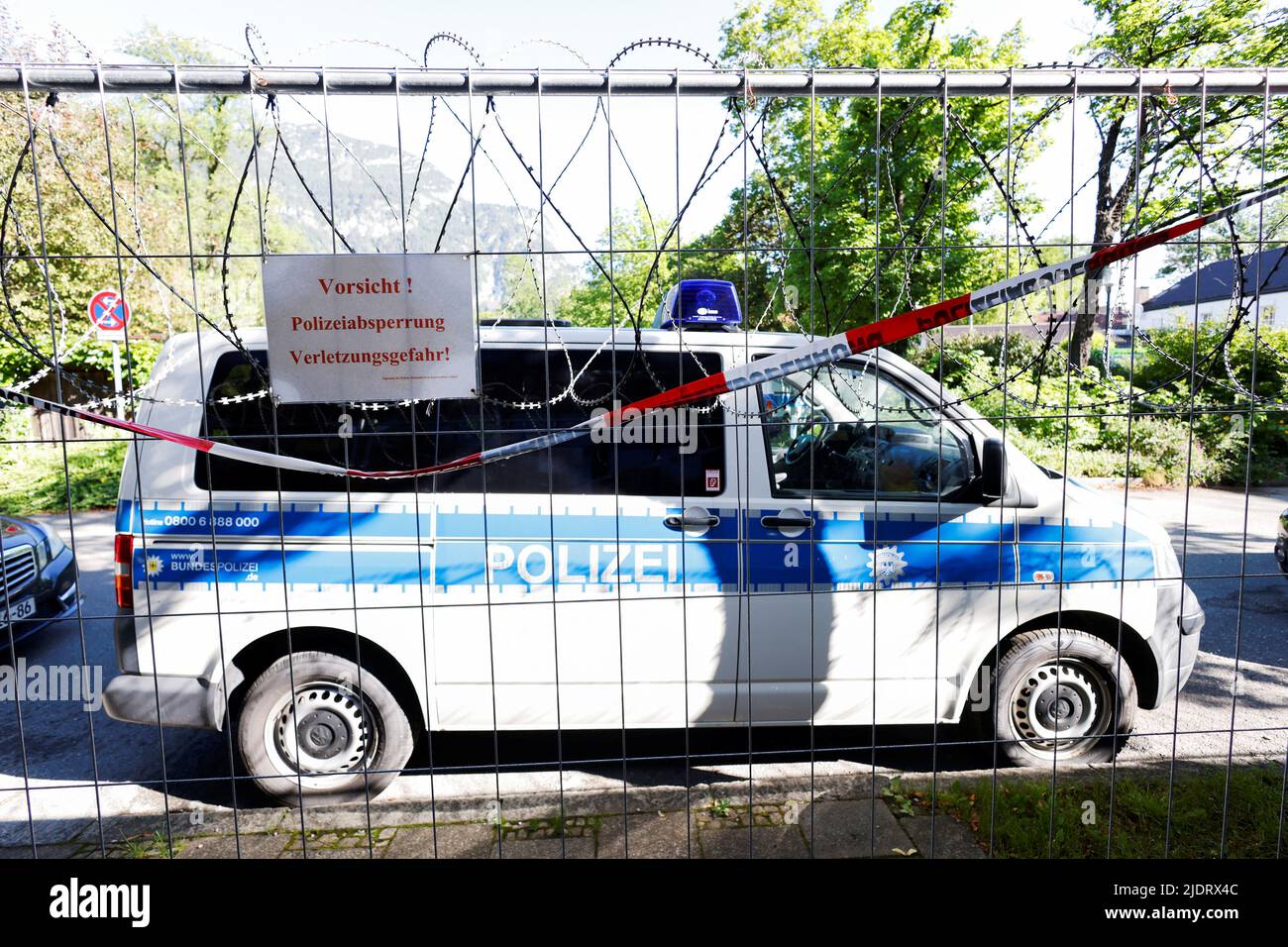 German police car parked behind a barbed wire fence in the southern Bavarian resort where the G7 Summit will be held, in Garmisch-Partenkirchen, Germany, June 23, 2022. REUTERS/Michaela Rehle Stock Photo