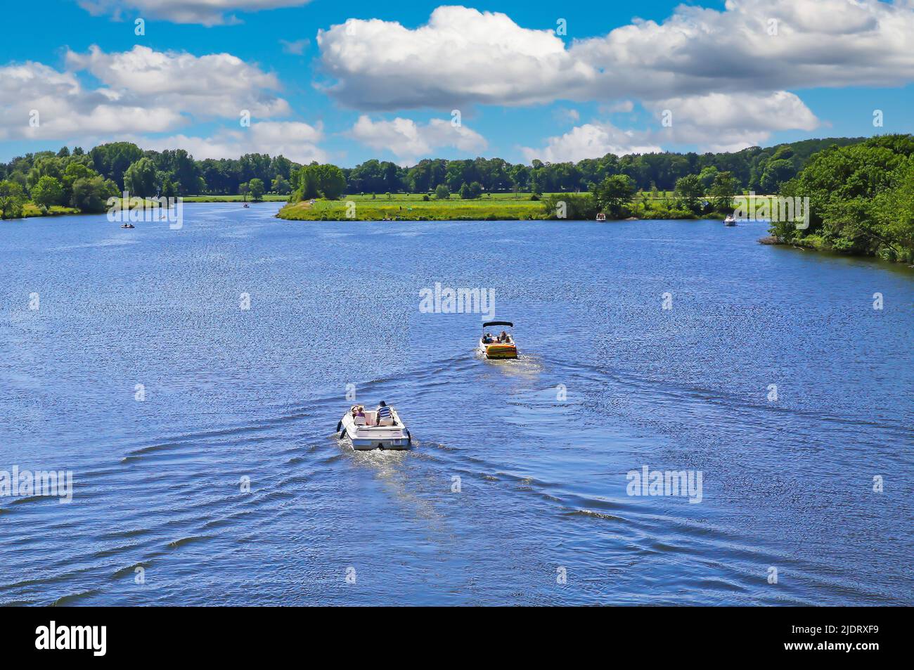 Beautiful idyllic dutch lakescape, 2 motor sport boats, green forest, ,blue summer sky - Leukermeer, Netherlands Stock Photo