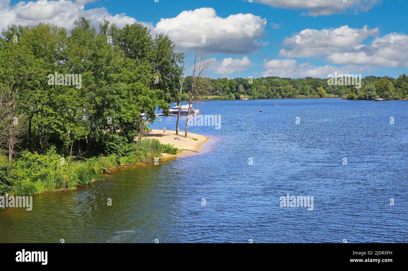 Beautiful idyllic dutch lake, boats on water, small sand beach, green forest, blue summer sky - Leukermeer, Limburg, Netherlands Stock Photo