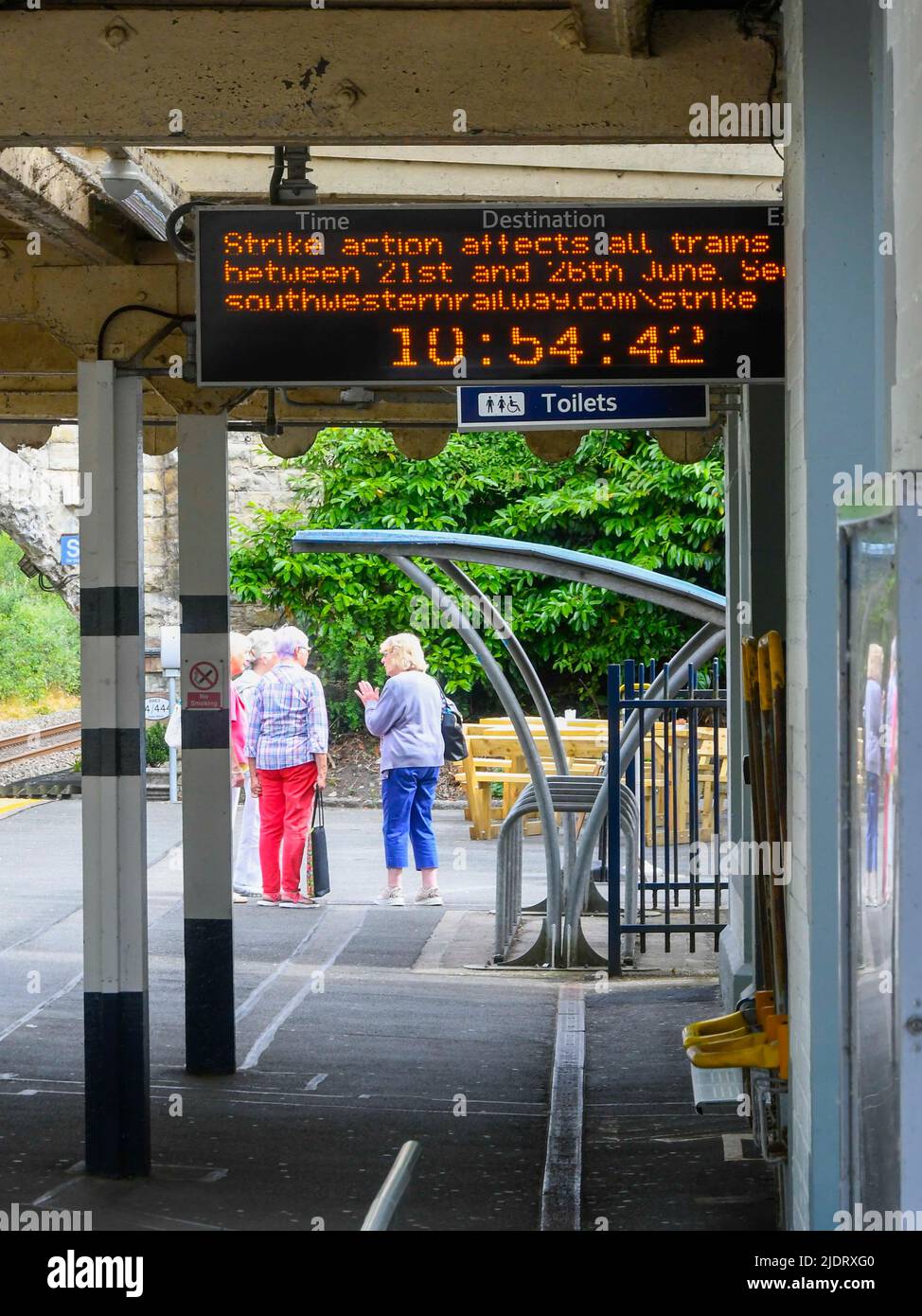Axminster, Devon, UK.  23rd June 2022.  A strike action message on the electronic train departure board on the platform at the station at Axminster in Devon on the London Waterloo to Exeter line where their are no trains during the second day of the RMT National Rail Strike. Buses waiting outside the station.  Picture Credit: Graham Hunt/Alamy Live News Stock Photo
