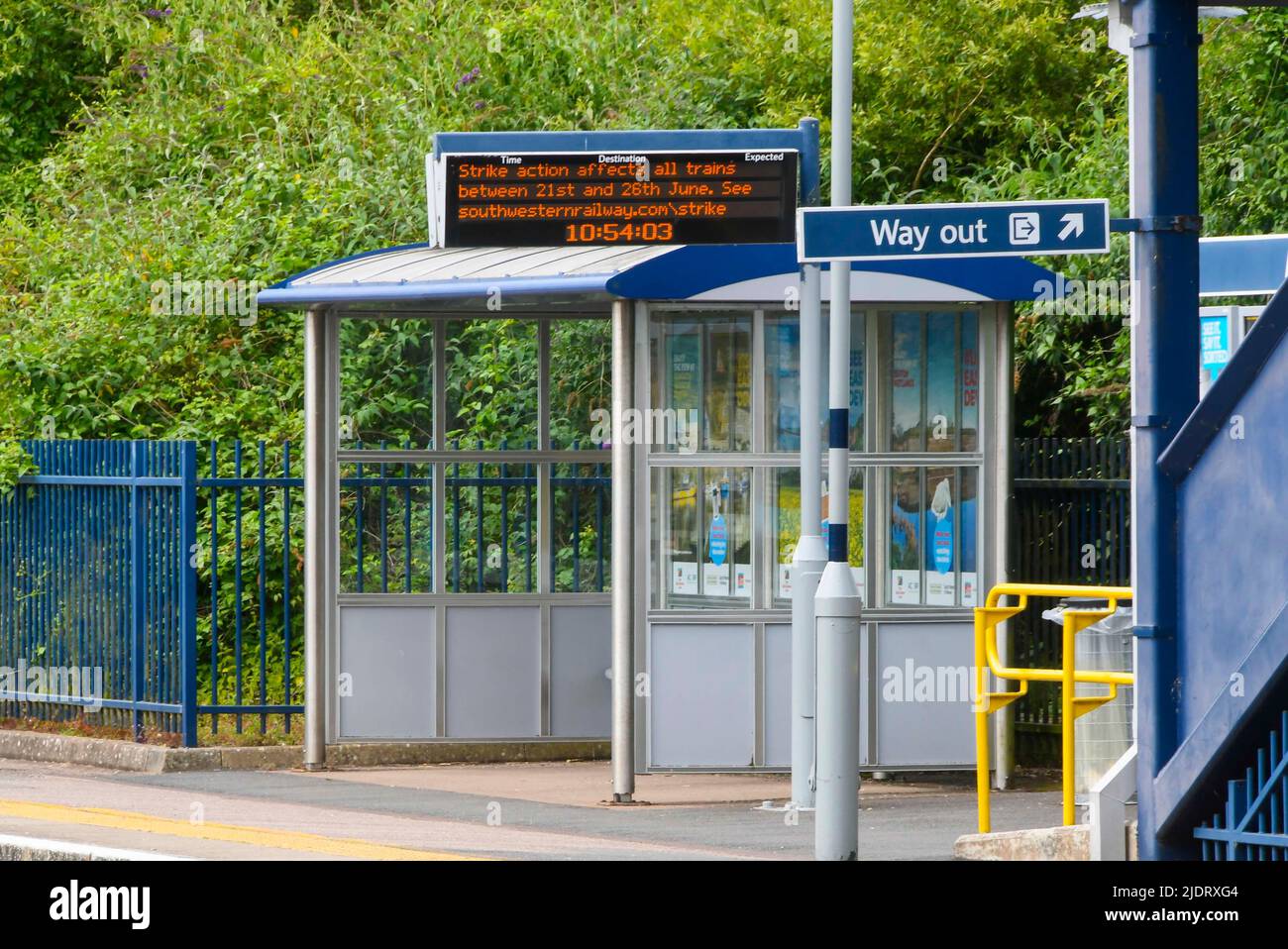 Axminster, Devon, UK.  23rd June 2022.  A strike action message on the electronic train departure board on the platform at the station at Axminster in Devon on the London Waterloo to Exeter line where their are no trains during the second day of the RMT National Rail Strike. Buses waiting outside the station.  Picture Credit: Graham Hunt/Alamy Live News Stock Photo