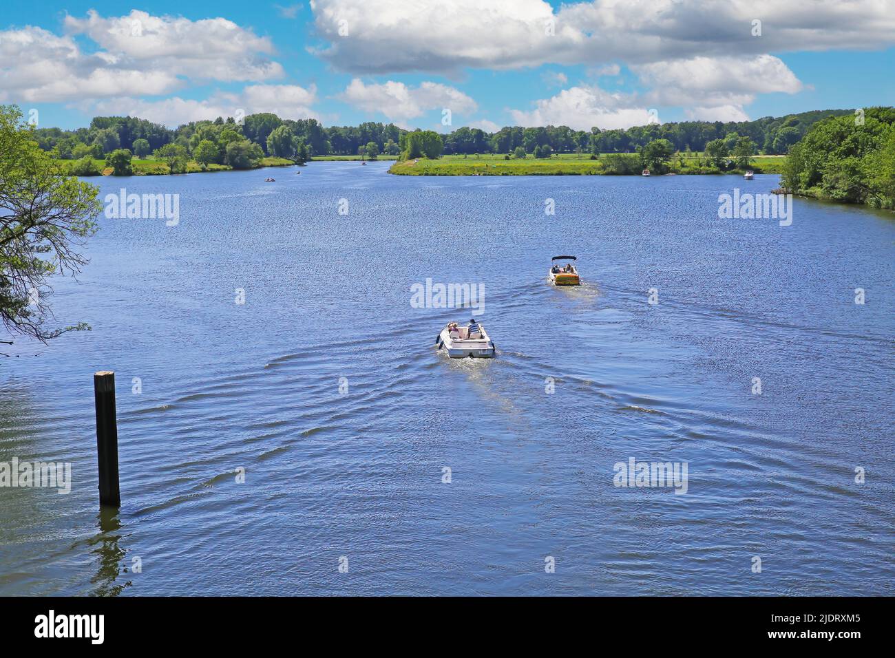 Beautiful idyllic dutch lakescape, 2 motor sport boats, green forest, ,blue summer sky - Leukermeer, Netherlands Stock Photo